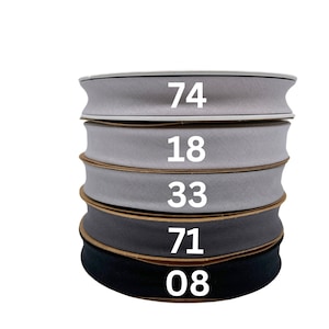 May include: Five spools of gray and black fabric ribbon stacked on top of each other. The numbers 74, 18, 33, 71, and 08 are printed on the spools.