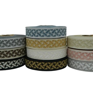 May include: A collection of eight spools of decorative trim with a woven pattern. The trim is available in a variety of colours, including blue, brown, gold, white, black, and pink.