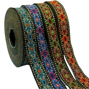May include: Four spools of black trim with colourful embroidered patterns. The trim features geometric shapes and floral designs in shades of red, blue, green, and gold.