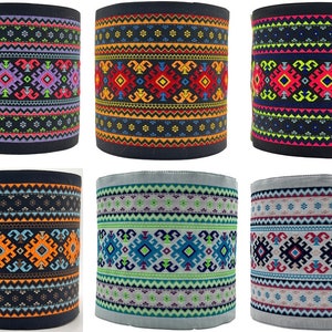 Può includere: Sei diversi campioni di tessuto con motivi geometrici colorati. I motivi sono di vari colori, tra cui rosso, blu, verde, giallo, arancione e nero. Il tessuto è di colore blu scuro.