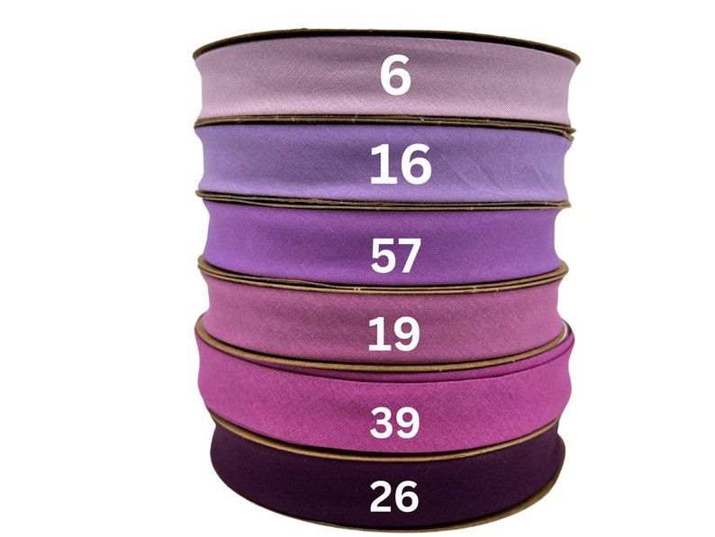 May include: Six spools of purple fabric ribbon stacked on top of each other. The spools are labeled with the numbers 6, 16, 57, 19, 39, and 26.