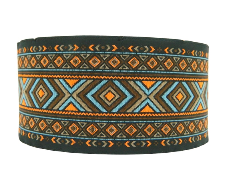 May include: A black fabric band with a geometric pattern in orange, blue, and brown. The pattern is made up of diamonds, triangles, and zigzags.