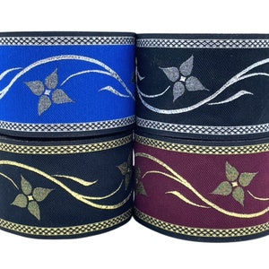 Può includere: Quattro rotoli di passamaneria decorativa con un motivo floreale. La passamaneria è nera con dettagli dorati, nera con dettagli argentati, blu con dettagli argentati e bordeaux con dettagli dorati.