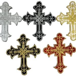 May include: Five embroidered iron-on patches in the shape of a cross. The crosses are silver, black, white, gold, and red.