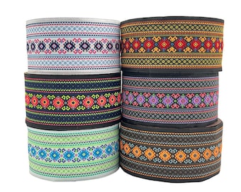 May include: Five rolls of colorful patterned trim with geometric designs. The trim is black with a variety of colors including red, blue, green, yellow, and purple.