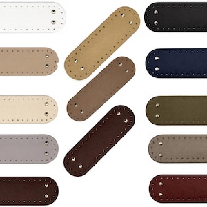 Op de afbeelding: Een collectie rechthoekige, leerachtige patches met afgeronde uiteinden, voorzien van voorgeponste stikgaatjes langs de rand en twee zilverkleurige metalen klinknagels aan elke kant, verkrijgbaar in diverse kleuren waaronder wit, zwart, blauw en bruin.