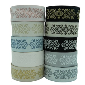 May include: A stack of ten decorative elastic trim ribbons with a repeating floral pattern. The ribbons are in various colours including pink, beige, blue, white, grey, and black.