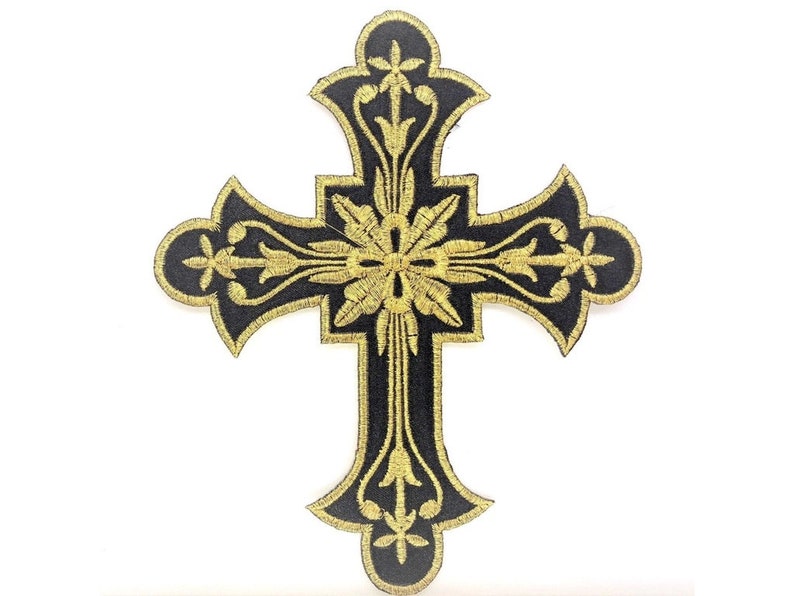 Może przedstawiać: Czarny haftowany krzyż z złotymi kwiatowymi detalami. Krzyż jest symbolem religijnym, często używanym w sztuce i dekoracji chrześcijańskiej.