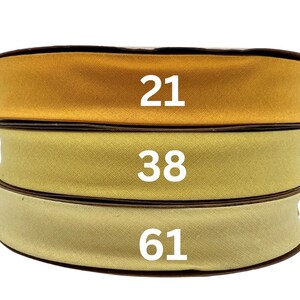 May include: Three rolls of yellow fabric ribbon with the numbers 21, 38, and 61 printed on them.