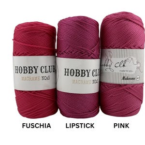 Drei Makramee-Garne von Hobby Club in den Farben Fuchsia, Lipstick und Pink, auf weißem Hintergrund nebeneinander angeordnet.
