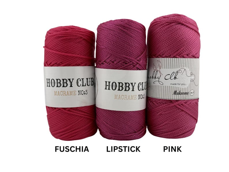 Drei Makramee-Garne von Hobby Club in den Farben Fuchsia, Lipstick und Pink, auf weißem Hintergrund nebeneinander angeordnet.