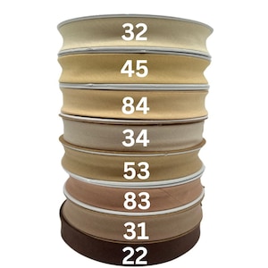 May include: A stack of eight beige and brown fabric ribbon rolls with numbers printed on each roll: 32, 45, 84, 34, 53, 83, 31, and 22.