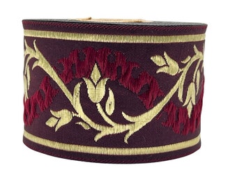 May include: Burgundy and gold trim ribbon with a floral design. The ribbon has a raised texture and is perfect for adding a touch of elegance to any project.