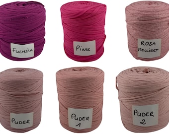 Op de afbeelding: Zes cilindrische klossen textielgaren gerangschikt in twee rijen. De bovenste rij bevat fuchsia, roze en lichtroze garen met de labels Fuchsia, Pink en Rosa Melliert. De onderste rij toont drie klossen oudroze garen met de labels Puder, Puder 1 en Puder 2.