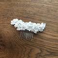 White porcelain flower hair comb for bride. White porcelain flower comb for bride. Bridal headdress with flowers in cold white porcelain. product logo