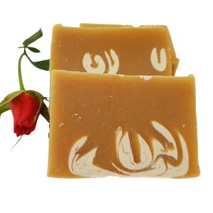 May include: Two bars of handmade soap with a swirl design. The soap is a light brown color with white swirls. The soap is sitting on a white background.