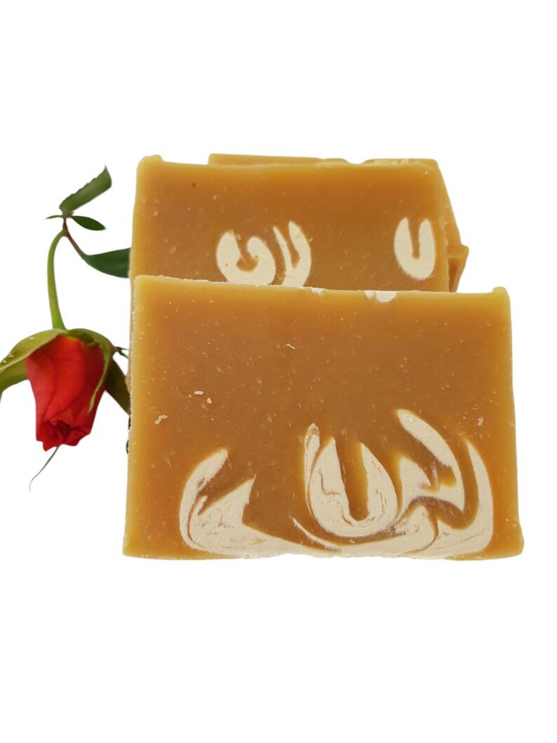 May include: Two bars of handmade soap with a swirl design. The soap is a light brown color with white swirls. The soap is sitting on a white background.