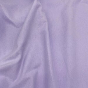 Puede incluir: Primer plano de una tela lavanda suave, con textura sutil y pliegues delicados. La tela tiene un acabado mate y parece estar drapeada, creando sombras y reflejos. La impresi&oacute;n general es de un material liso y fluido.