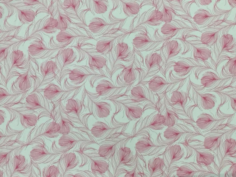 May include: A seamless fabric pattern featuring pink stylized feathers on a light green background.