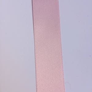 May include: A pale pink satin ribbon.