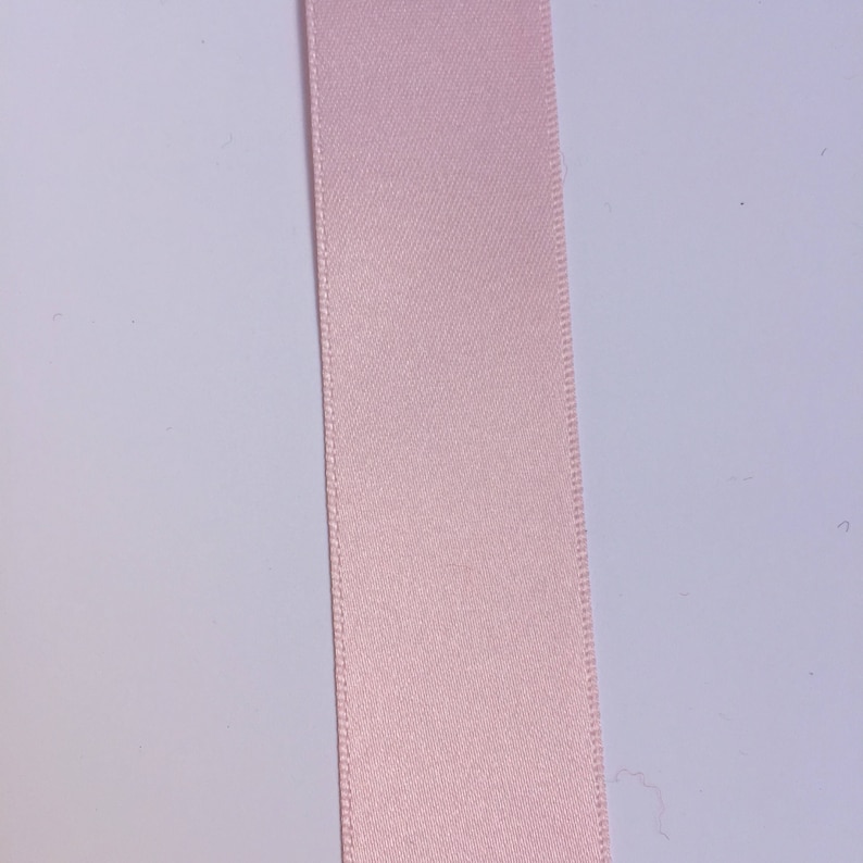 May include: A pale pink satin ribbon.