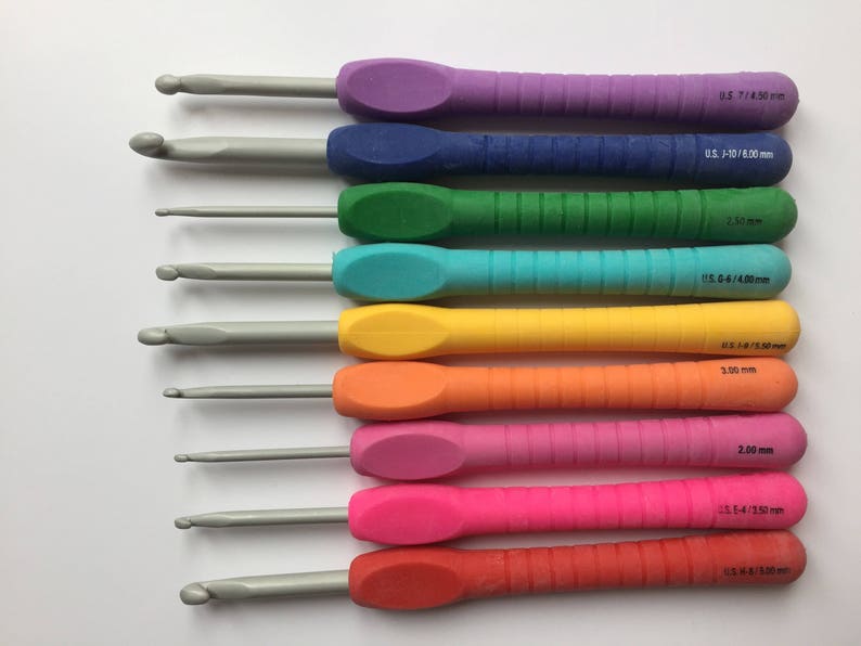 Puede incluir: Un juego de diez agujas de crochet de colores con diferentes tama&ntilde;os, que van desde US 1-10/6,00 mm hasta US H-8/5,00 mm. Las agujas est&aacute;n dispuestas en un patr&oacute;n de arco&iacute;ris, con la aguja m&aacute;s peque&ntilde;a en la parte superior y la aguja m&aacute;s grande en la parte inferior.