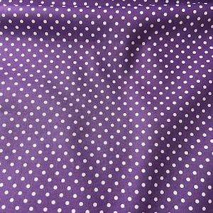 May include: A close-up shot of a purple fabric covered in a repeating pattern of white polka dots. The dots are uniformly spaced. The fabric has a smooth texture and may be made of a synthetic material.