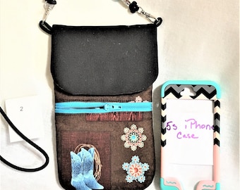 May include: A black crossbody phone case with a zipper closure and a brown fabric lining featuring a western-themed design with blue boots, a lasso, and floral accents. The case is shown next to a black and white chevron phone case with the text "5s iPhone Case".