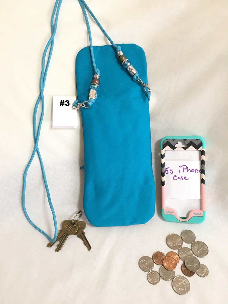 May include: A turquoise phone case with a beaded strap and a key chain. The case is labelled #3. A pink and grey phone case with the text "5s iPhone Case" is also pictured.