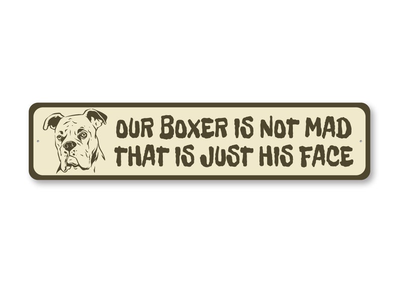 Puede incluir: Un letrero de metal beige con un contorno marr&oacute;n y una ilustraci&oacute;n en blanco y negro de un perro boxer. El letrero dice "Nuestro Boxer no est&aacute; enojado, esa es solo su cara."