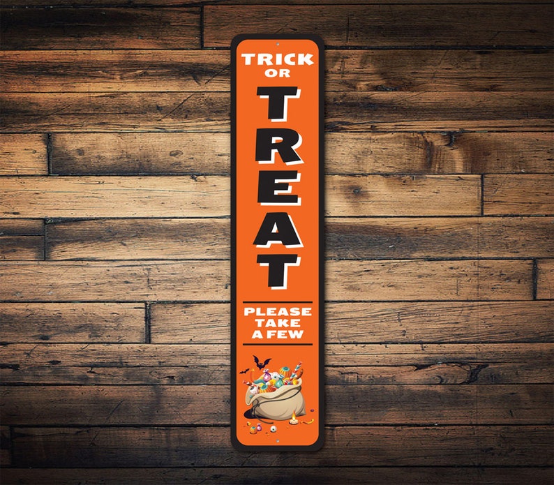 May include: Orange and black metal sign with the text "Trick or Treat" and "Please take a few". The sign features a cartoon illustration of a bag of sweets.