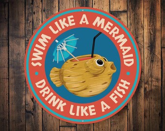 May include: A round, red and blue sign with the text "Swim Like A Mermaid Drink Like A Fish" in white. A cartoon fish with a drink inside is depicted in the center.