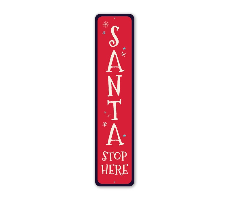 May include: Red metal sign with white text that reads "SANTA STOP HERE" with snowflakes in blue and white around the word "SANTA".