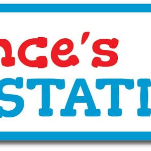 May include: A blue and white sign with the text "Lance's Train Station" in red and blue letters. A red toy train with yellow and green accents is on the right side of the sign.