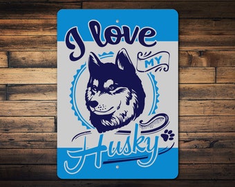 Könnte beinhalten: Ein blaues und weißes Metallschild mit dem Text "Ich liebe meinen Husky" in einer stilisierten Schrift. Das Schild zeigt eine schwarz-weiße Silhouette eines Husky-Hundekopfes.