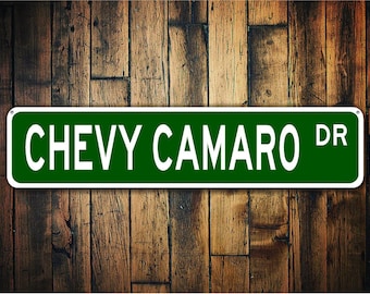 May include: Green street sign with white text that reads "CHEVY CAMARO DR".