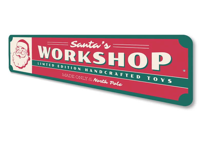 May include: A red and green metal sign with the text "Santa's Workshop" in white. The sign also includes the text "Limited Edition Handcrafted Toys Made Only at the North Pole". A cartoon image of Santa Claus is in the upper left corner of the sign.