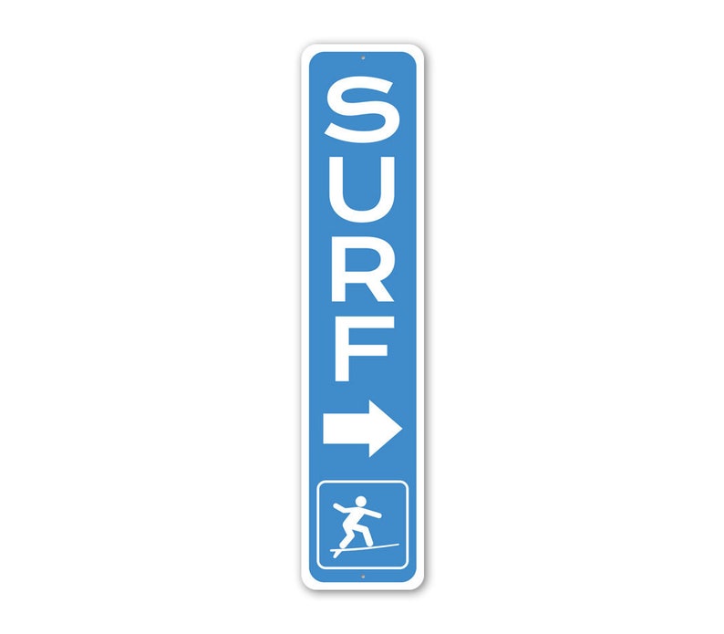 Pode incluir: Uma placa vertical azul e branca com a palavra "SURF" em letras brancas e uma seta apontando para a direita. A placa tamb&eacute;m apresenta uma silhueta branca de uma pessoa surfando.