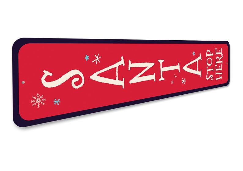 May include: Red metal sign with white text that reads "Santa Stop Here". The sign has a white arrow pointing to the right and snowflakes in blue and white.