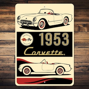 May include: A vintage-style metal sign featuring a cream-colored 1953 Corvette convertible. The sign includes the Chevrolet logo, the year "1953", and the word "Corvette" in a classic font. The sign is rectangular with a cream and black background.