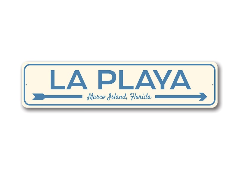 May include: A blue and white sign with the text "LA PLAYA Marco Island, Florida" and two arrows pointing in opposite directions.