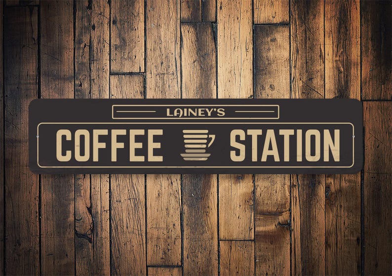 May include: A black and gold sign with the text "Lainey's Coffee Station" and a stylized image of a coffee cup.