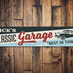 May include: Rectangular metal sign with the text "RICK'S CLASSIC Garage" in white and red, with a vintage car illustration. The sign also includes the phrase "BEST IN TOWN!" on a light blue background.