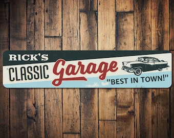 Puede incluir: Letrero metálico rectangular con el texto "RICK'S CLASSIC Garage" en blanco y rojo, con una ilustración de coche clásico. El letrero también incluye la frase "BEST IN TOWN!" sobre un fondo azul claro.