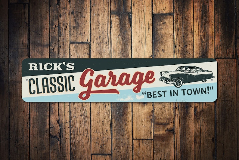 May include: Rectangular metal sign with the text "RICK'S CLASSIC Garage" in white and red, with a vintage car illustration. The sign also includes the phrase "BEST IN TOWN!" on a light blue background.