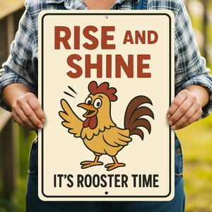 Peut inclure: Panneau rectangulaire avec les mots "RISE AND SHINE" en lettres marron au-dessus d'une illustration de coq de dessin animé. Le coq est jaune, marron et rouge, avec le texte "IT'S ROOSTER TIME" en dessous.