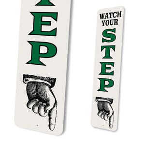 two signs with the same text and a hand pointing to the right.