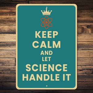 May include: A teal sign with the words "KEEP CALM AND LET SCIENCE HANDLE IT" in a cream-colored font. The sign features a crown and an atom symbol. The background is a wooden wall.