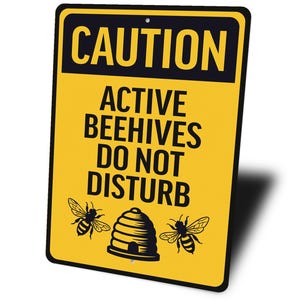 a yellow caution sign that says, active beehives do not disturb