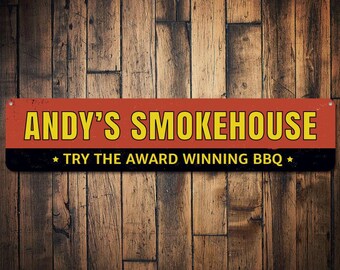 May include: A red and black sign with white lettering that reads "ANDY'S SMOKEHOUSE" and "TRY THE AWARD WINNING BBQ".